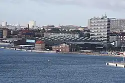 Photographie d'une zone portuaire urbaine ; au premier plan, un entrepôt marqué du logo de l'UNICEF.