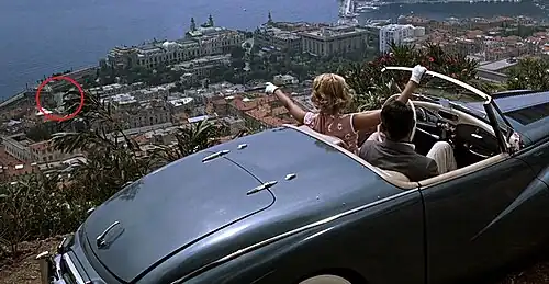 Grace Kelly dans le film La Main au collet d'Alfred Hitchcock, pointant du doigt l'avenue qui portera son nom.