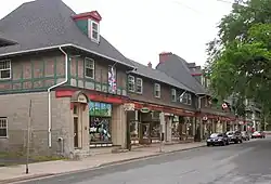 Photo couleur d'une rue bordée de commerces.