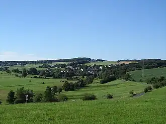 Blick über Busenhausen hinweg nordnordwestwärts zum Beulskopf mit dortigem Raiffeisen-Turm