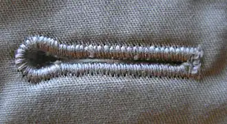 Maschinell gefertigtes Knopfloch mit Auge