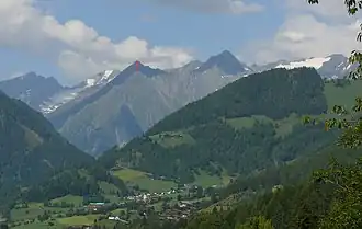 Mullwitzkogel (roter Pfeil), gesehen von Zedlach (von Osten). Er wird umrahmt von den Dreitausendern (von links): Daberspitze, Rötspitze, Ogasilspitze (direkt hinter Mullwitzkogel), Steingrubenkogel, Quirl und den Malhamspitzen.