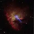 Die Röntgenstrahlung des eingebetteten Clusters IC 1590 ist in der Aufnahme des Röntgenteleskops Chandra violett zu sehen.