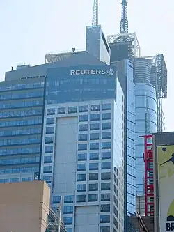Turmspitze mit Antenne und Reuters-Logo im Jahr 2006, dahinter Four Times Square.