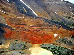 Ein windgepeitschter Berg mit rot-orangen Felsen