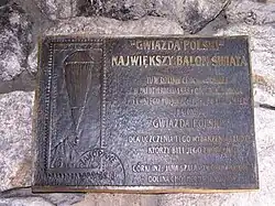 Metalowa tablica pamiątkowa z wizerunkiem balonu i napisem informującym o próbie pierwszego polskiego lotu do stratosfery balonem »Gwiazda Polski«, przeprowadzonej w Dolinie Chochołowskiej w październiku 1938 roku